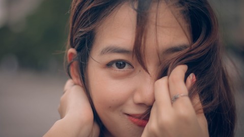selective focus photography of woman covering her face